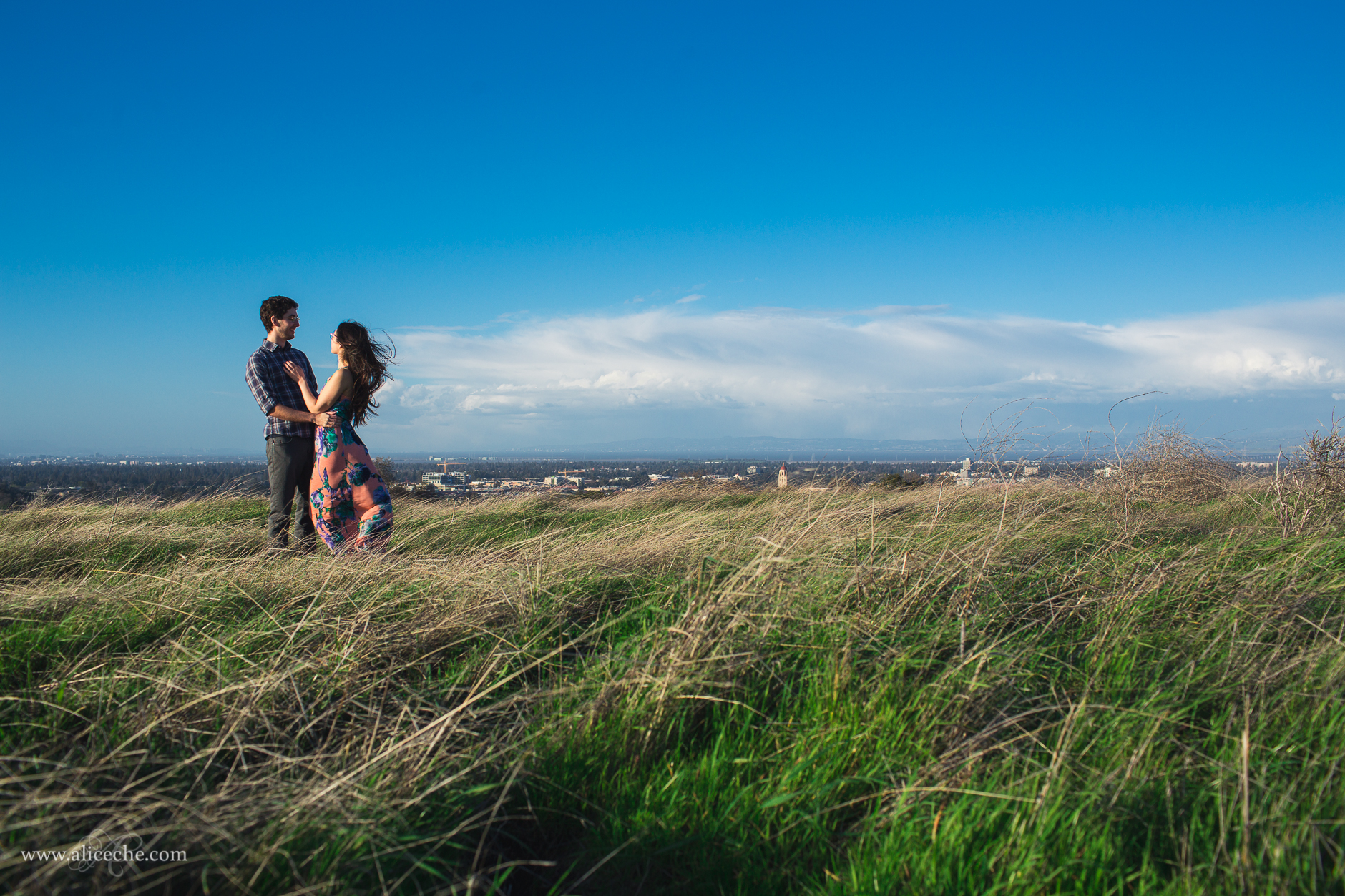 alice-che-photography-stanford-dish-windswept-couple-blue-skies-green-grass