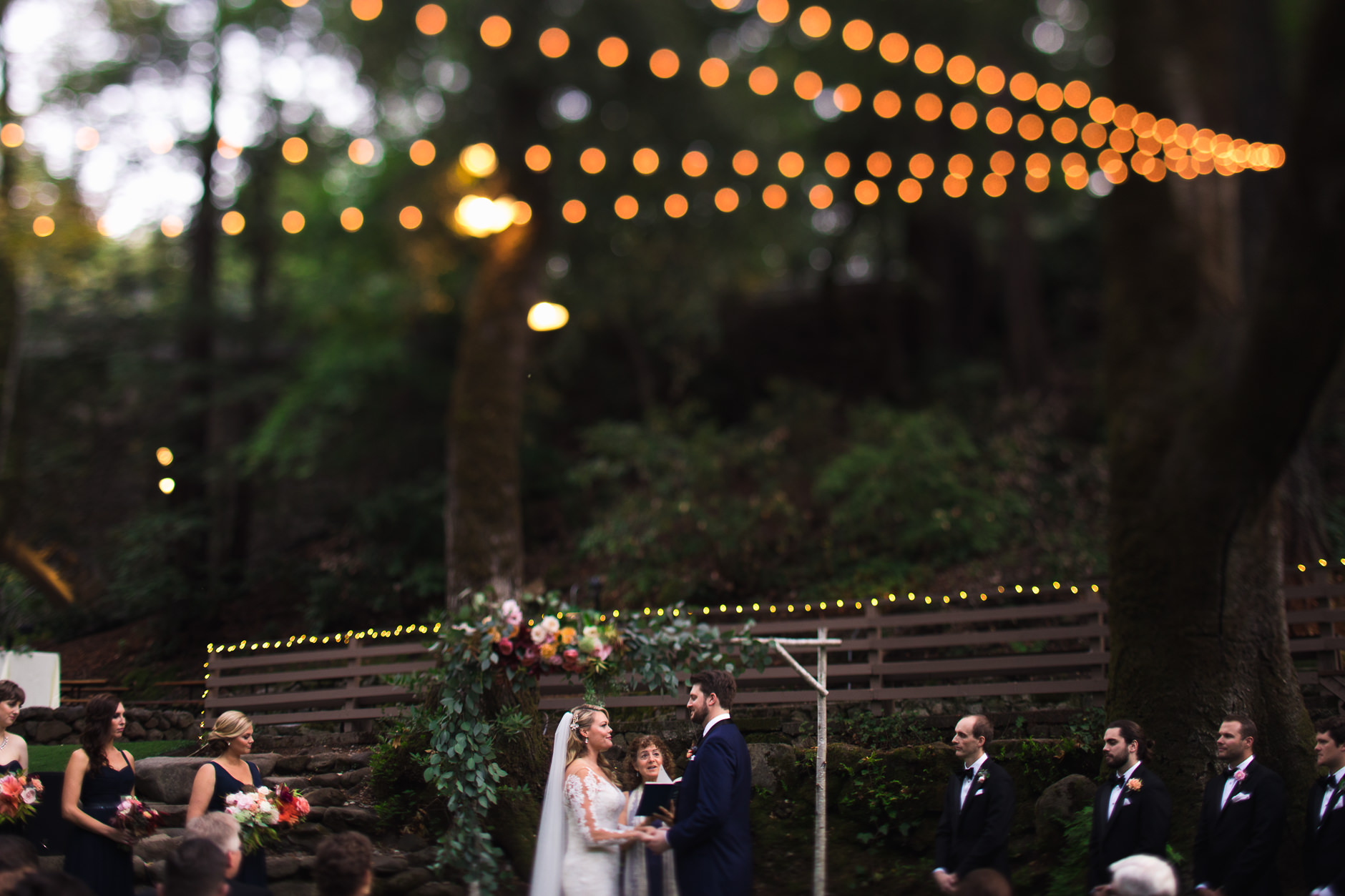 Saratoga Springs Wedding California San Francisco Photographer Bride and Groom during Ceremony under Redwoods and String Lights Tilt Shift