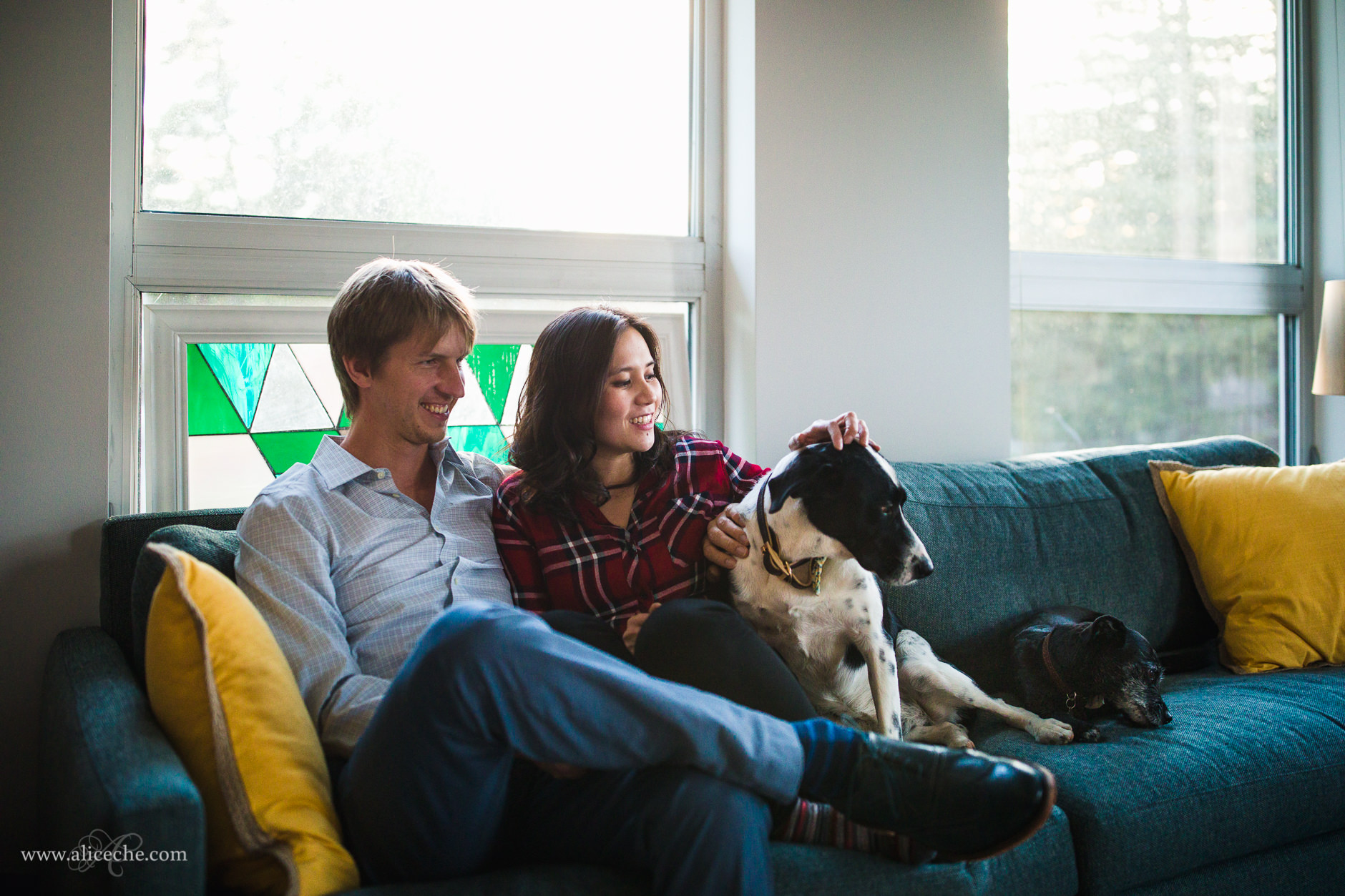 Redwood City In Home Engagement Session with Dogs Couple Cuddling on Couch with Dogs