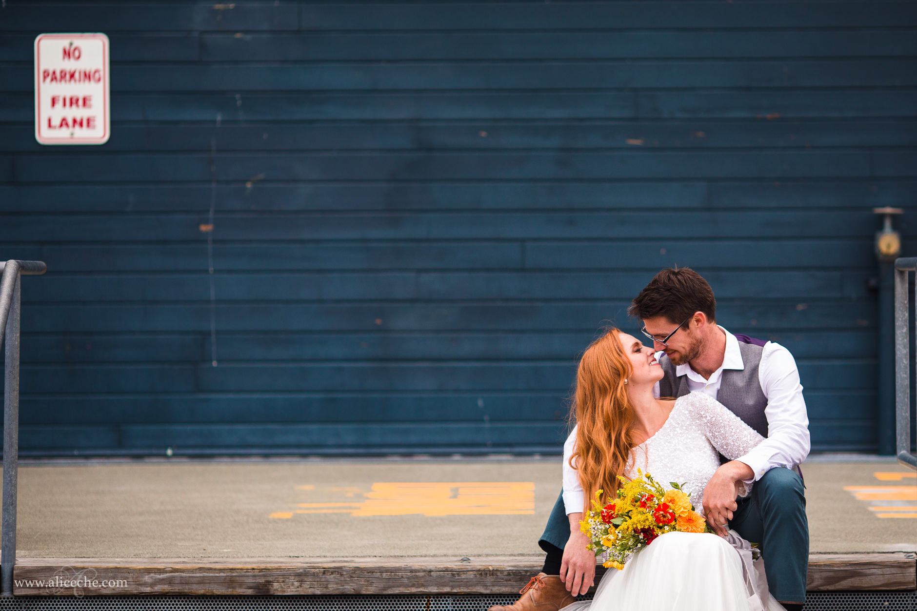 Groom and Red Haired bride in front of Blue Wall