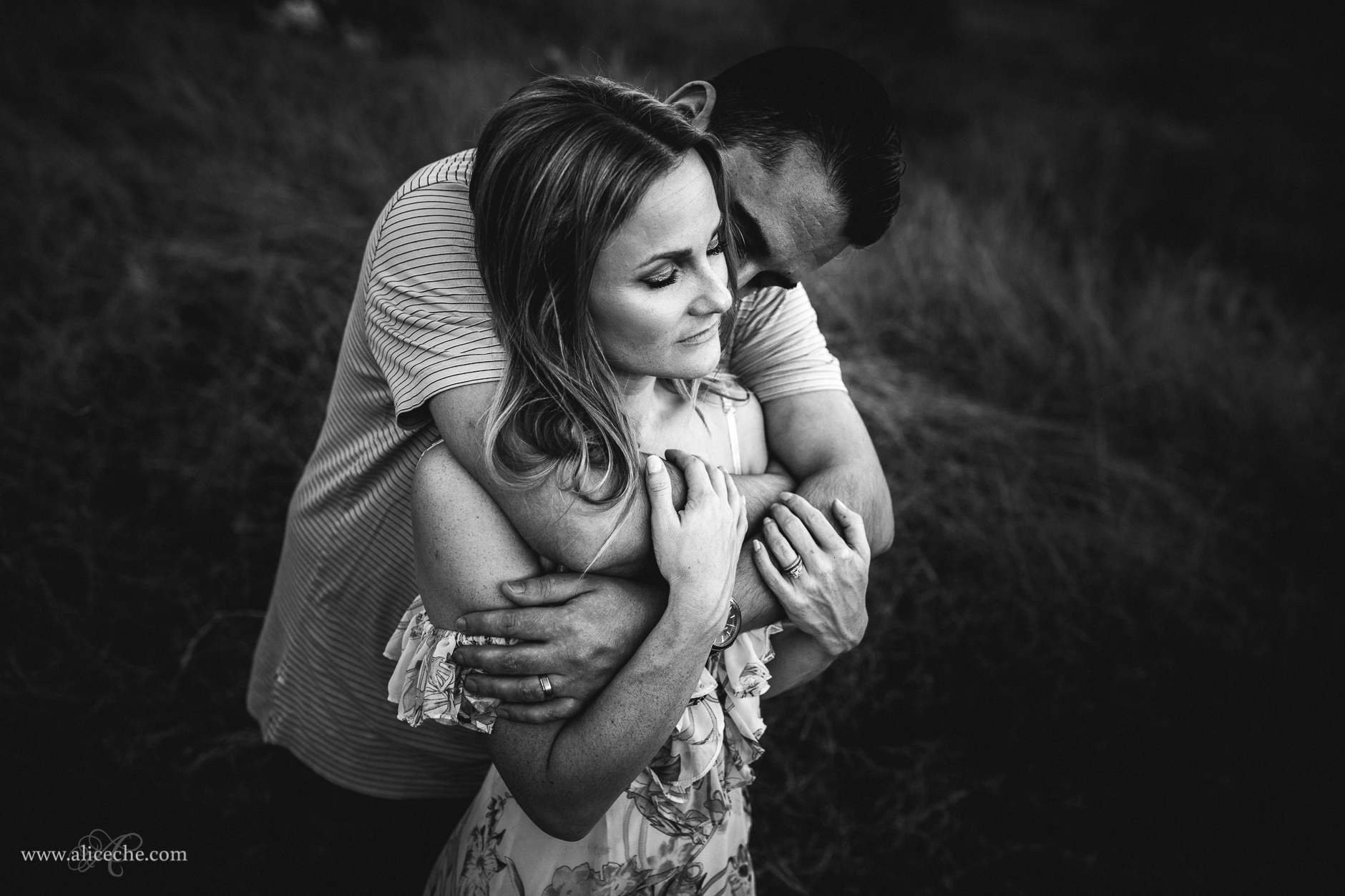 Couple Portraits in a Field Black and White Photo of Man with Arms Wrapped around Wife