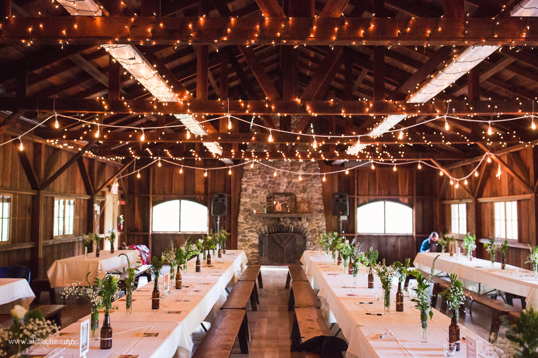 Wooden Wedding Reception Hall with Twinkle Light Wrapped Rafters in San Gregorio