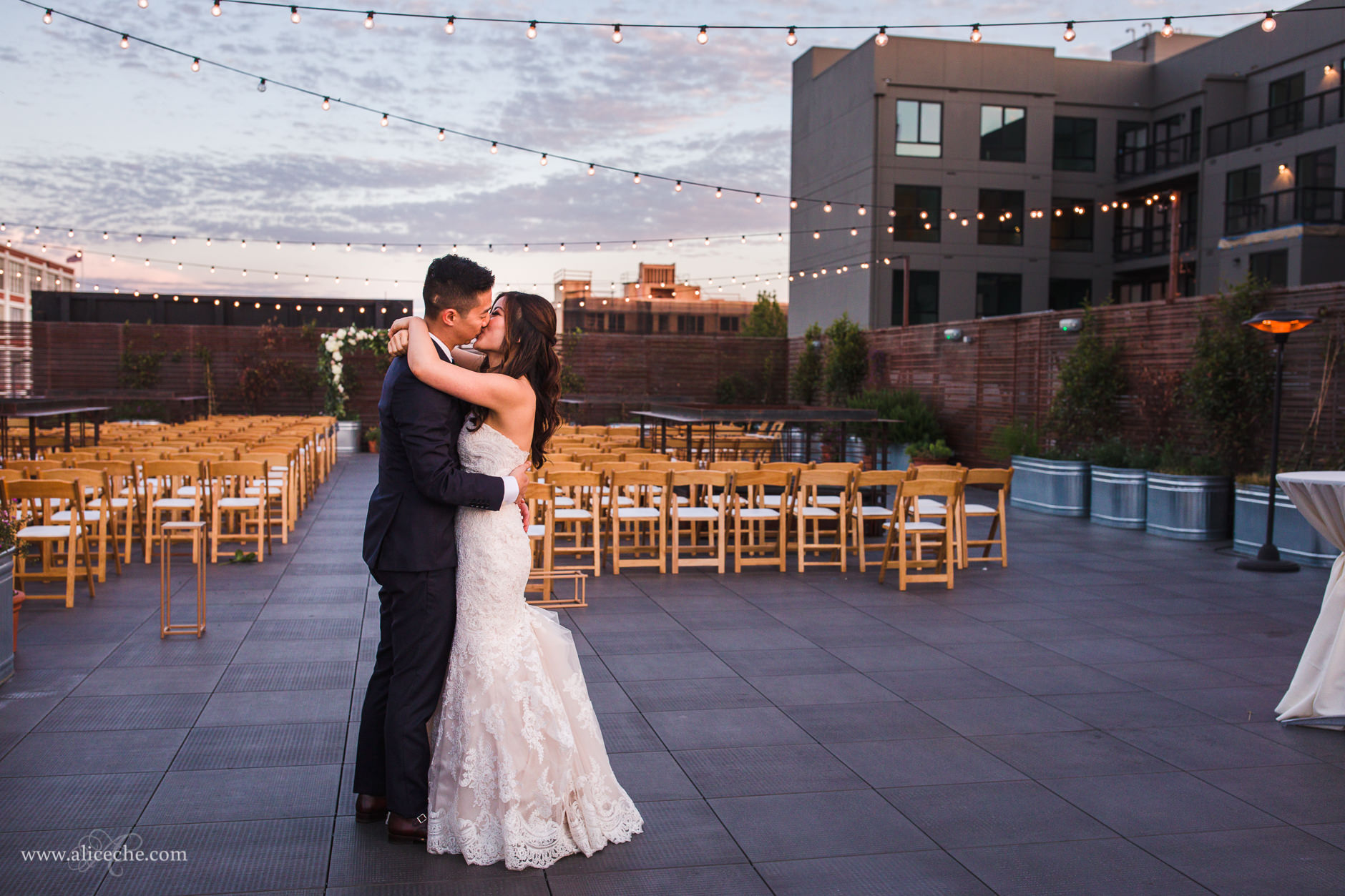 Bride and Groom Dancing on Rooftop under String Lights at The Pearl SF at sunset