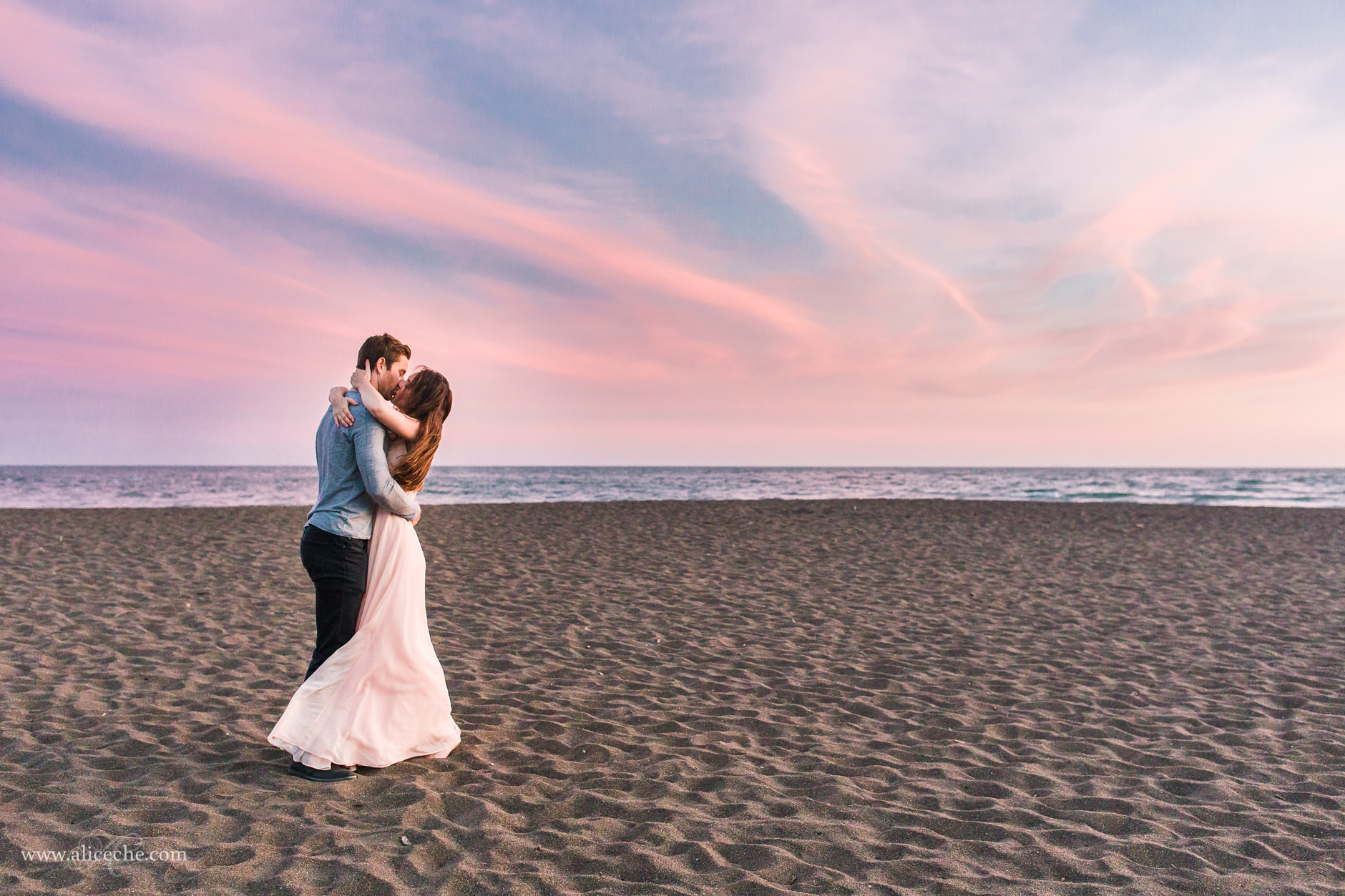 couple kissing on the beach at sunset 
