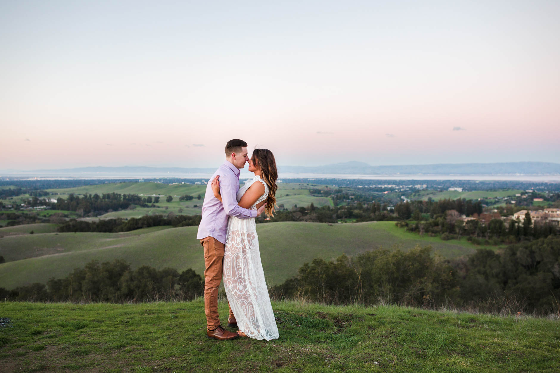 Foothills Park engagement session, couple hugging with view of the Bay behind them