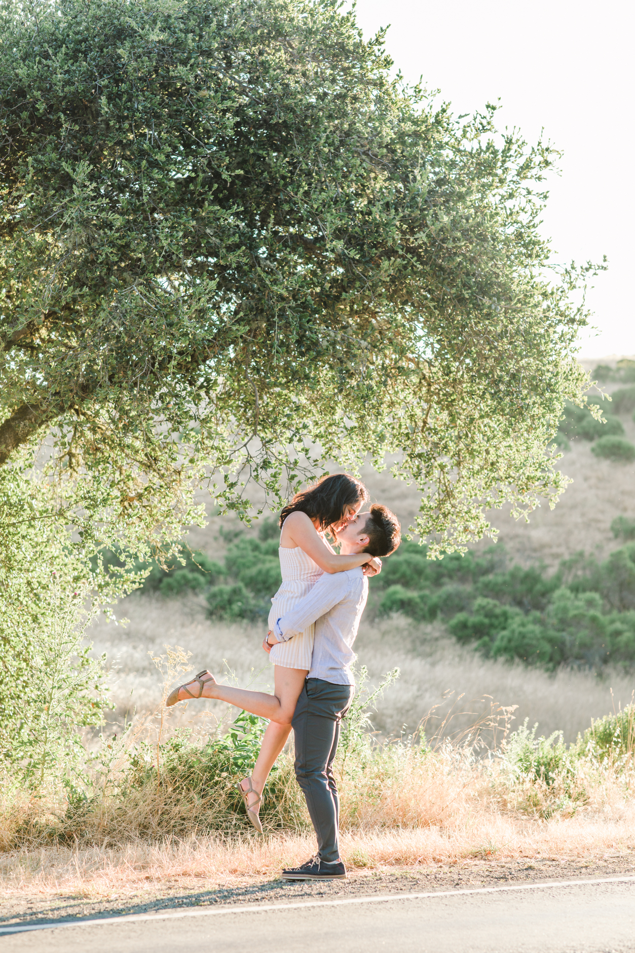 Silicon Valley engagement session groom lifting fiance by oak tree