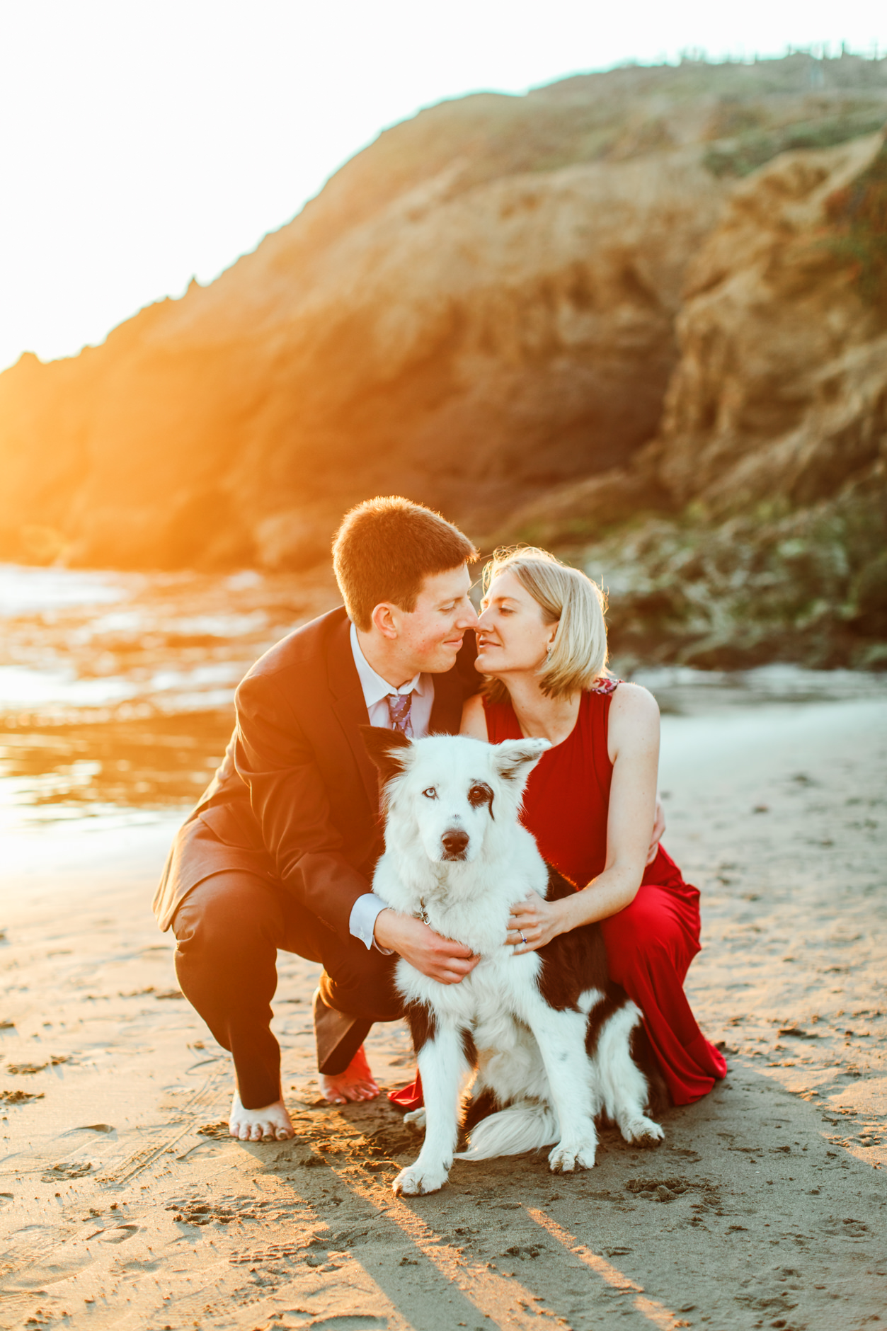 Couple with adorable pup at Rodeo Beach in beautiful light