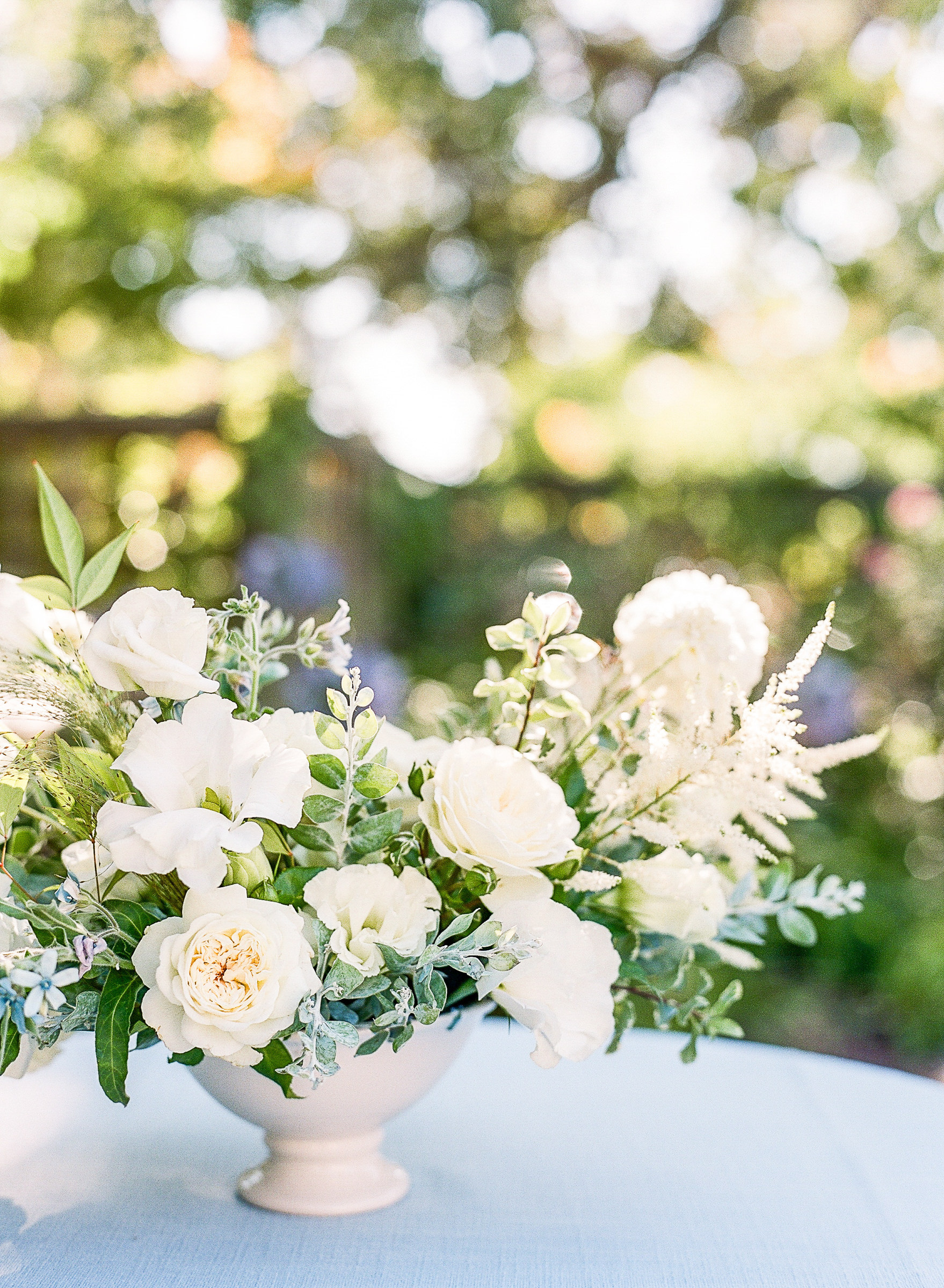 Stunning white floral centerpiece by Allie of Bloomwell and Co with small touches of blue