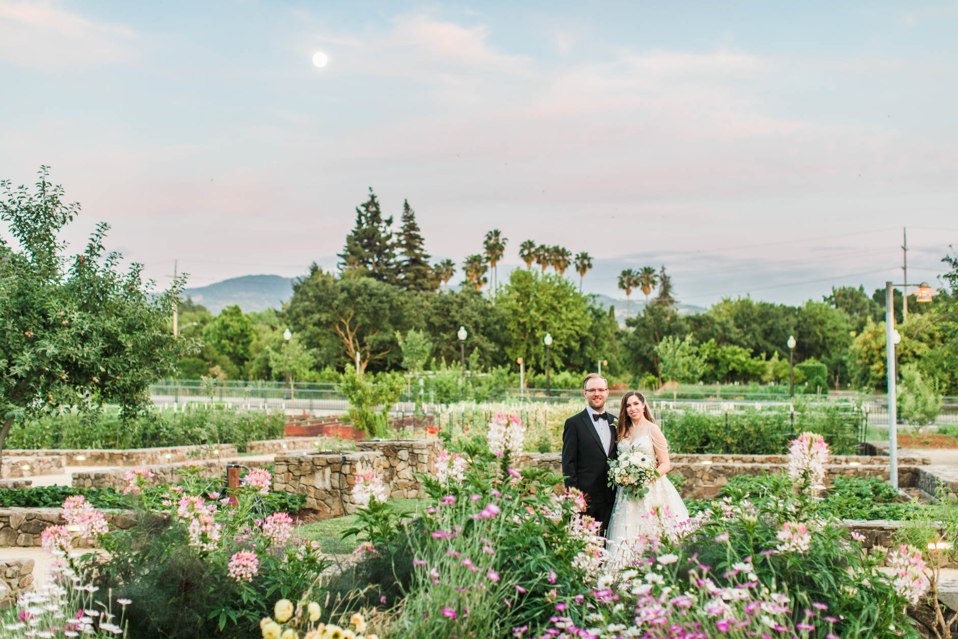 Bride and groom under the moon at sunset in CIA Copia garden