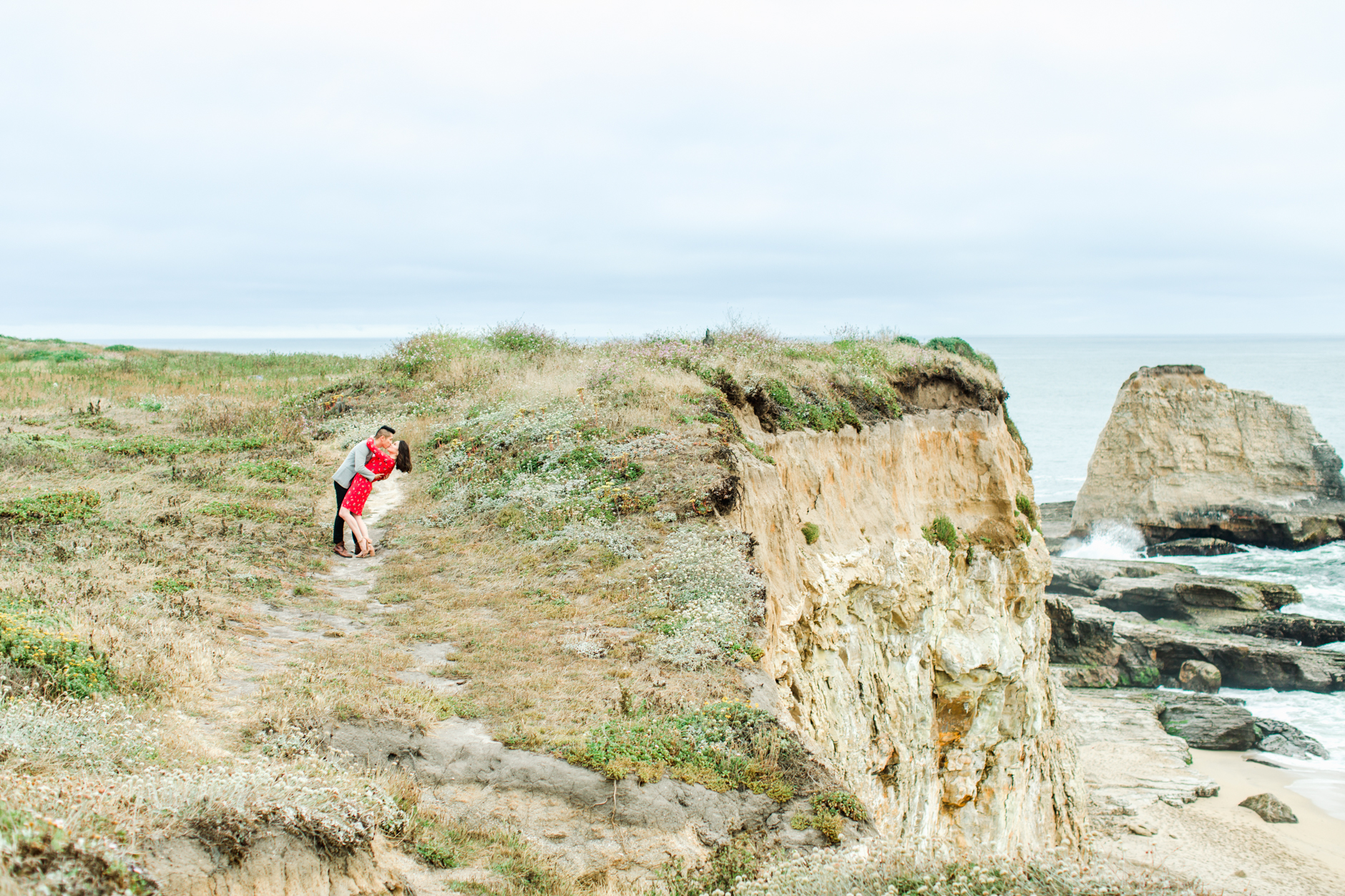 Coast Dairies Engagement Session Man kissing woman on the cliffs