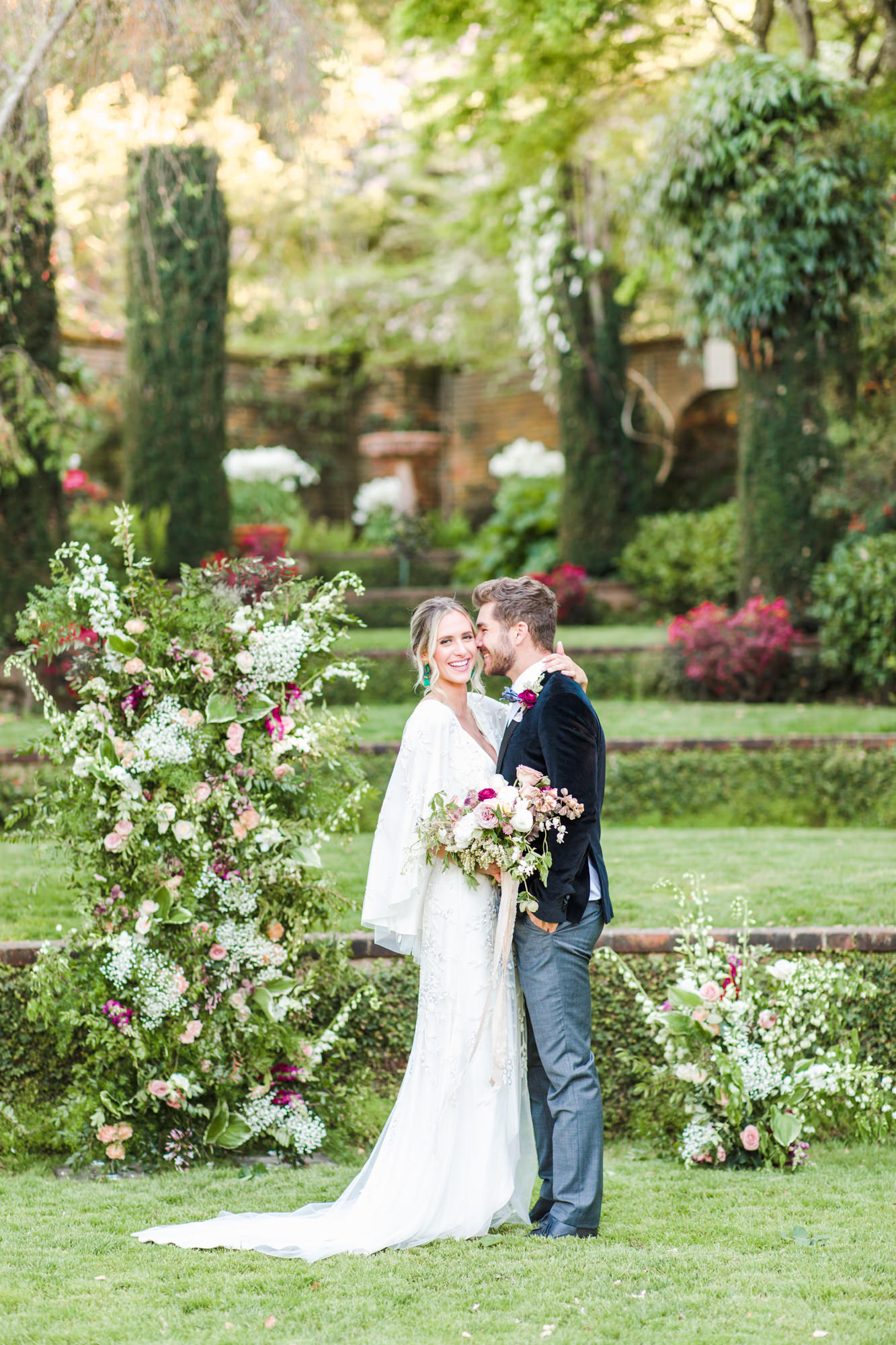Bride and Groom laughing during Filoli Garden Wedding with gorgeous floral backdrop by Tumbleweed Floral Truck